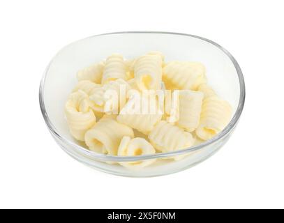 Savoureuses boucles de beurre dans un bol isolé sur blanc Banque D'Images