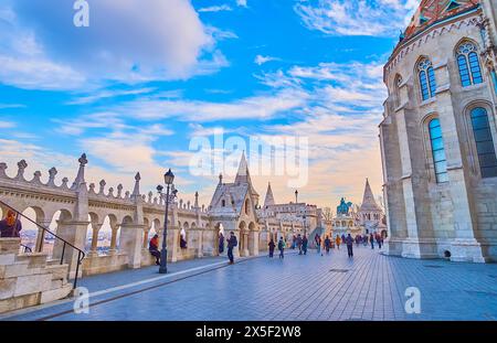 Admirez le coucher du soleil sur la place historique de la Sainte Trinité, célèbre pour ses monuments tels que le Bastion des pêcheurs et l'église Matthias, Budapest, Hongrie Banque D'Images