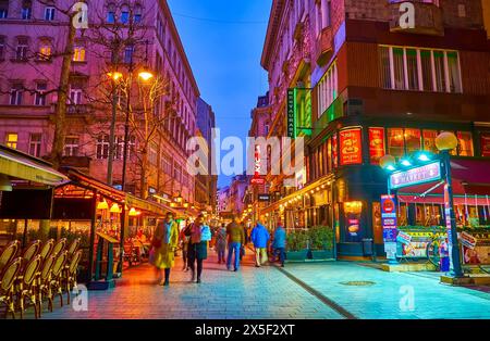 BUDAPEST, HONGRIE - 3 MARS 2022 : profitez de la promenade en soirée sur la rue touristique Vaci, célèbre pour ses restaurants, cafés, bars et boutiques de souvenirs, Budapest Banque D'Images