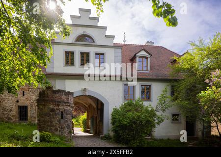 Torhaus Schloss Taubenheim Das Taubenheimer Schloss befindet sich im Ortszentrum auf einer Felskuppe über der Kleinen Triebisch. Es besteht aus vier unregelmäßig gestalteten, dreigeschossigen Gebäudeflügeln, die einen kleinen trapezförmigen Innenhof einschließen. DAS Haupteingangsportal liegt unterhalb des Turms an der Südostseite. IM Inneren befinden sich mehrere Räume mit historischen Parkettböden, bemalten Holzkassettendecken und einem Meißner Kachelofen. Zur Schlossanlage gehören ein zweistöckiges klassizistisches Gartenhaus und das Torhaus. IM Schlosspark stehen Sandsteinskulpturen und fr Banque D'Images