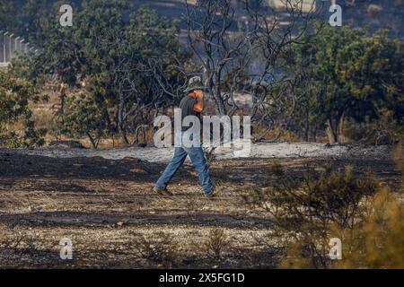 Limassol, Limassol, Chypre. 9 mai 2024. Un volontaire parle à son téléphone pendant l'incendie de Limassol, Chypre, en mai. 9, 2024. Un feu de forêt a éclaté dans la zone industrielle d'Ipsonas, à quelques kilomètres du centre de Limassol, qui a brûlé principalement de la végétation sauvage. (Crédit image : © Kostas Pikoulas/ZUMA Press Wire) USAGE ÉDITORIAL SEULEMENT! Non destiné à UN USAGE commercial ! Banque D'Images