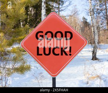 Symbole bonne chance. Mots conceptuels bonne chance sur le beau panneau rouge de la route. Beau fond de ciel bleu neige de forêt. Affaires, motivation bonne chance conc Banque D'Images