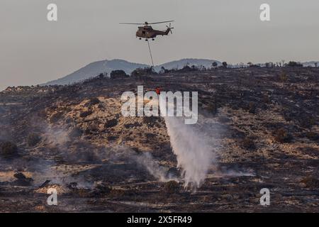 Limassol, Chypre. 9 mai 2024. Un hélicoptère lâche de l'eau pendant l'incendie près de Limassol, Chypre. Un feu de forêt a éclaté dans la zone industrielle d'Ipsonas, à quelques kilomètres du centre de Limassol, qui a brûlé principalement de la végétation sauvage. (Crédit image : © Kostas Pikoulas/ZUMA Press Wire) USAGE ÉDITORIAL SEULEMENT! Non destiné à UN USAGE commercial ! Banque D'Images