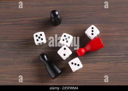 Beaucoup de dés blancs et de pièces de jeu de couleur sur la table en bois, pose à plat Banque D'Images