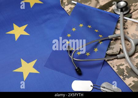 Stéthoscope, tags et uniforme militaire sur drapeau de l'Union européenne, gros plan Banque D'Images