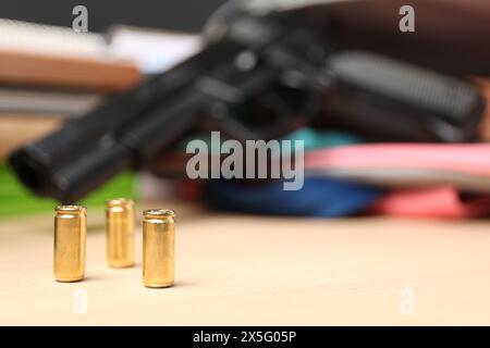 Pistolet et papeterie scolaire sur table en bois, foyer de balles. Espace pour le texte Banque D'Images