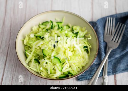 Délicieuse salade de coleslaw à base de chou et de concombre, servie dans un plat sur une surface en bois Banque D'Images