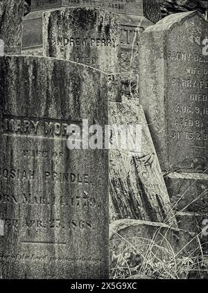 Une photographie en noir et blanc d'une collection de pierres tombales vieilles et érodées, certaines à peine lisibles, retrouvées dans un cimetière datant de 1720 Banque D'Images