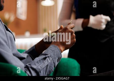 Homme afro-américain tenant de l'argent donnant de l'argent à l'employé de l'hôtel, donnant des pourboires serveur, image en gros plan. Client satisfait le client donne un pourboire au café ou au restaurant, montrant son appréciation pour le bon service Banque D'Images