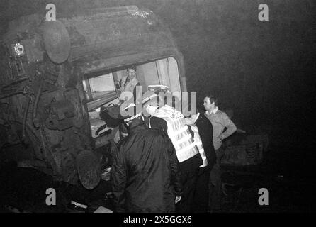 Un wagon d'un London Midland Express déraillé voyageant de London Euston à Manchester Picadilly après avoir heurté un rail cassé en passant par Bushey Station. 19 personnes ont été grièvement blessées. Secouristes aidant un passager blessé. Bushey, Hertfordshire près de Watford. 16 février 1980 80-0411 Banque D'Images