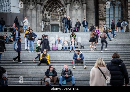 Photo d'un groupe de trois filles assis sur les marches de la cathédrale de cologne, buvant un café et se relaxant avant de voyager en train dans GE Banque D'Images