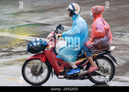 SAMUT PRAKAN, THAÏLANDE, 20 mars 2024, en couple à moto sous la pluie Banque D'Images