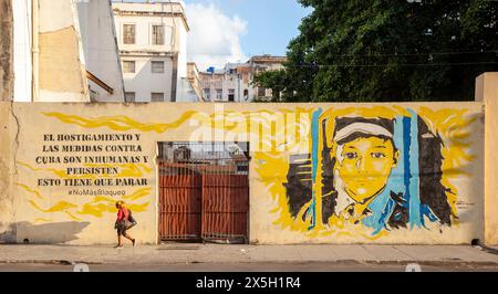 Femme passe la murale de la Havane. Le texte dit: "Le harcèlement et les mesures contre Cuba sont inhumains et persistent, cela doit cesser. Plus de blocus Banque D'Images