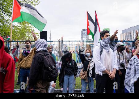 Les manifestants pro-palestiniens lèvent les armes et agitent des drapeaux palestiniens pendant la manifestation. Manifestants pro-palestiniens et pro-israéliens à l'Université de Toronto devant le camp étudiant occupant King College Circle. Plaidant pour les droits des Palestiniens, les étudiants et les professeurs ont affiché des banderoles illustrant le sort des Palestiniens, des messages anti-sionistes et anti-israéliens, tandis que les manifestations pro-israéliennes ont impliqué des étudiants et des sympathisants en agitant des drapeaux israéliens et en engageant des dialogues pour défendre les actions et les politiques d'Israël. Banque D'Images