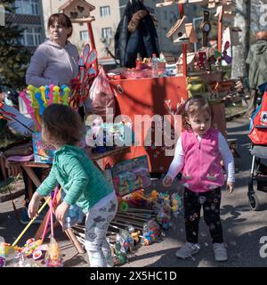 Belgrade, Serbie, 23 mars 2024 : des enfants jouent autour de la stalle de jouets dans la rue. Banque D'Images