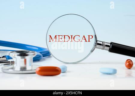 Concept médical. MEDIGAP sur fond bleu à travers une loupe Banque D'Images
