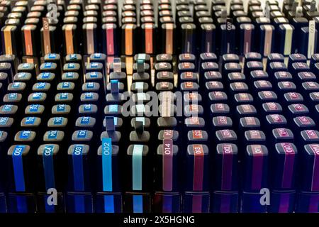 Une grande vitrine avec de nombreux pots de vernis à ongles de différentes couleurs, disposés en rangées. Les pots sont disposés de manière à mettre en valeur leur co Banque D'Images