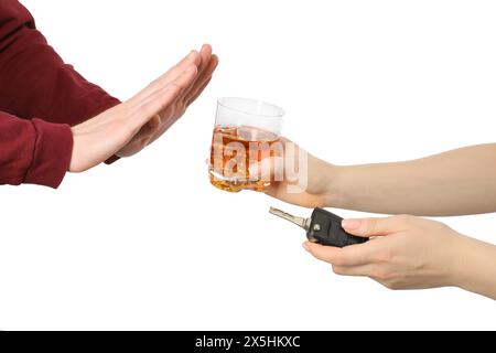 Homme refusant la boisson alcoolisée tandis que femme lui suggérant des clés de voiture et verre de whisky sur fond blanc, gros plan. Ne pas boire et conduire concept Banque D'Images