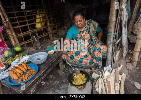 Bangladesh, Khulna, Sonadanga. Une femme cuisine sur un feu d'argile dans son petit restaurant. (Usage éditorial uniquement) Banque D'Images