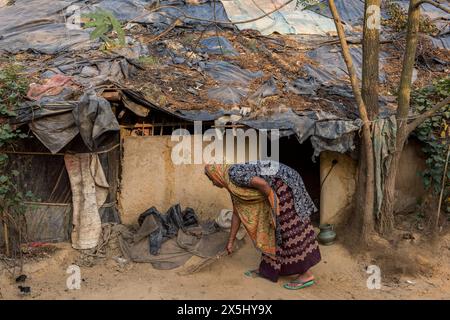 Bangladesh, Cox's Bazar. Une femme balaie son escabeau avant dans le camp de réfugiés Rohingya de Kutupalong. (Usage éditorial uniquement) Banque D'Images
