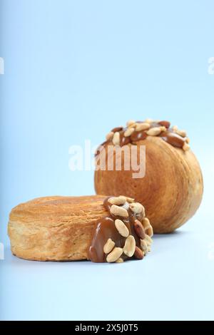 Croissants suprêmes avec de la pâte de chocolat et des noix sur fond bleu clair. Pâte feuilletée savoureuse Banque D'Images