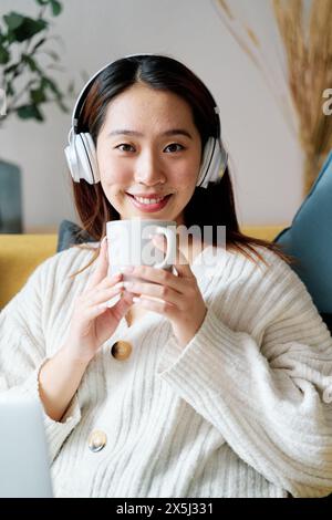 Une femme dans un casque tenant une tasse Banque D'Images