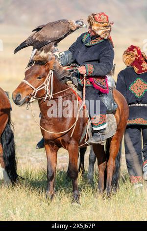 Asie, Mongolie, Province de Bayan-Oglii. Altaï Eagle Festival, jeune Kazakh pose avec son aigle. (Usage éditorial uniquement) Banque D'Images