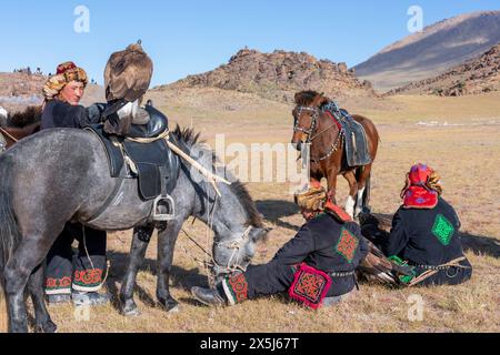 Asie, Mongolie, Province de Bayan-Oglii. Altaï Eagle Festival, les chasseurs d'aigle kazakhs avec leurs chevaux et aigles attendent les résultats du concours. (Usage éditorial uniquement) Banque D'Images