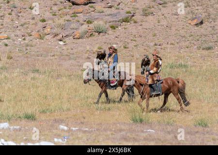 Asie, Mongolie, Province de Bayan-Oglii. Altaï Eagle Festival, deux chasseurs d'aigle kazakhs à cheval portent leurs aigles. (Usage éditorial uniquement) Banque D'Images