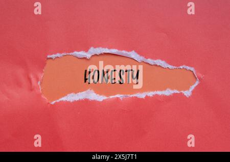 Mot d'honnêteté écrit sur papier déchiré avec fond orange. Symbole d'honnêteté conceptuel. Copier l'espace. Banque D'Images