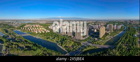 Wujiaqu. 9 mai 2024. Une photo aérienne panoramique prise par drone le 9 mai 2024 montre une vue de la ville de Wujiaqu, la région autonome ouïgur du Xinjiang, au nord-ouest de la Chine. Au cours des dernières années, Wujiaqu, une cité-jardin nationale située dans la région autonome ouïgur du Xinjiang, au nord-ouest de la Chine, a déployé de grands efforts pour promouvoir des projets de verdissement et optimiser l'environnement de vie écologique. À la fin de 2023, Wujiaqu possédait plus de 15 700 mu (environ 1 046,7 hectares) d'espaces verts urbains, avec un taux de couverture verte de plus de 45 pour cent. Crédit : HU Huhu/Xinhua/Alamy Live News Banque D'Images