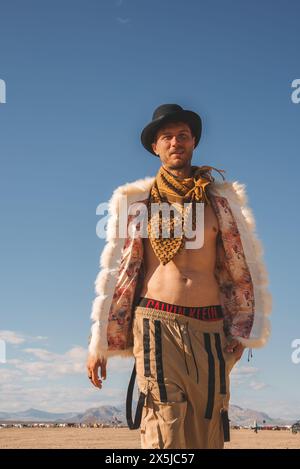 Homme à la mode dans Desert Festival Outfit, Blue Sky Landscape Banque D'Images