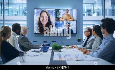 Visioconférence dans la salle de réunion du bureau : les directeurs exécutifs discutent avec un groupe d'entrepreneurs, de gestionnaires et d'investisseurs multiethniques. Les gens d'affaires discutent de la stratégie d'investissement dans le commerce électronique Banque D'Images
