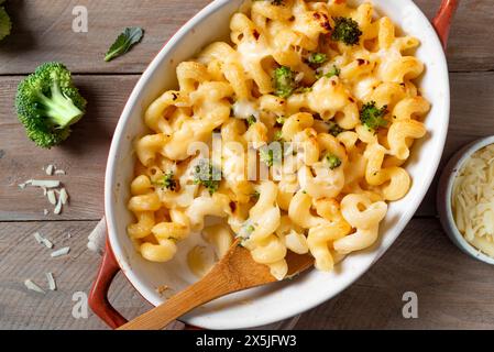Mac et fromage avec brocoli et parmesan cuit au four, vue de dessus. Repas américain traditionnel, pâtes macaronis crémeuses et sauce au fromage. Banque D'Images