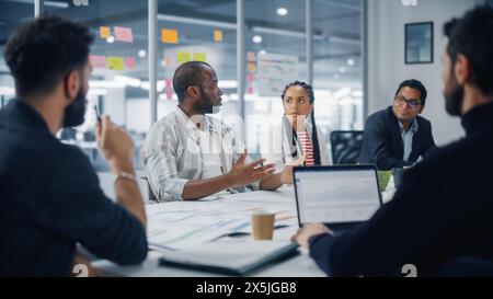 Diverse Modern Office : Portrait of Successful Black Businessman Leads Meads, parle de la croissance de l'entreprise. Les entrepreneurs numériques travaillent sur le projet e-commerce. Milieu de travail professionnel multiethnique créatif Banque D'Images