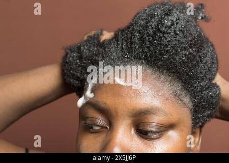 Laver les cheveux bouclés avec un shampooing, shampooing 4c cheveux froids, frotter les cheveux bouclés pendant le lavage Banque D'Images