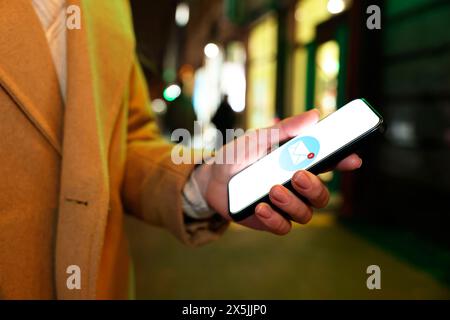 Femme a reçu un message sur téléphone portable à l'extérieur, gros plan. Illustration de l'enveloppe sur l'écran du périphérique Banque D'Images