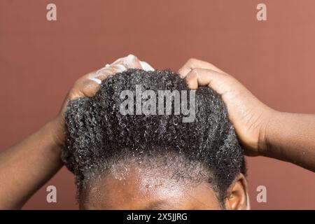 Laver les cheveux bouclés avec un shampooing, shampooing 4c cheveux froids, frotter les cheveux bouclés pendant le lavage Banque D'Images