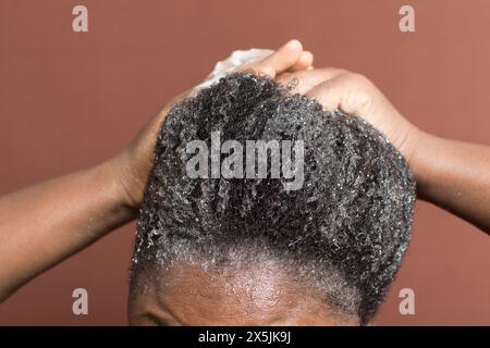 Laver les cheveux bouclés avec un shampooing, shampooing 4c cheveux froids, frotter les cheveux bouclés pendant le lavage Banque D'Images