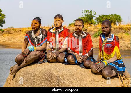 Femmes Mundari en robes traditionnelles, avec des cicatrices faciales et des cendres sur les visages, posant sur un rocher, tribu Mundari, Soudan du Sud, Afrique Copyright : MichaelxR Banque D'Images