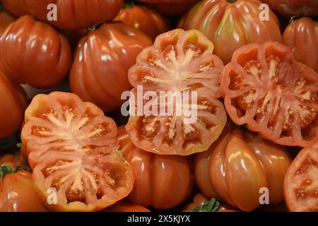 Tomates espagnoles rouges certaines coupées en deux, d'autres entières Banque D'Images