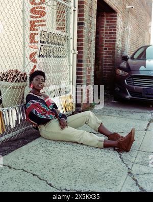 USA, New York, Portrait de jeune femme à la mode appuyée contre la clôture Banque D'Images
