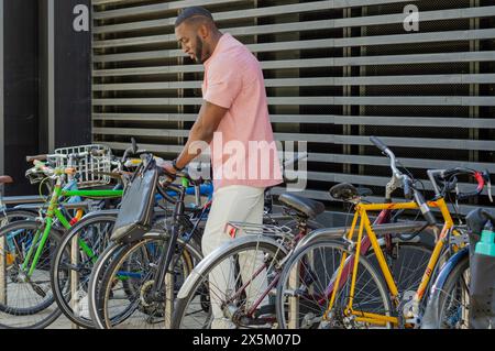 Homme tirant le vélo hors du porte-vélos Banque D'Images