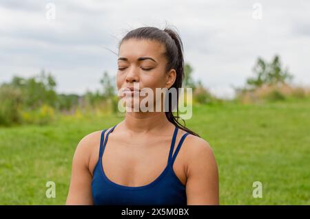 Woman meditating outdoors Banque D'Images