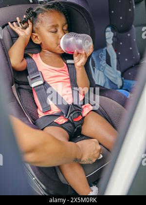 Femme attachant la ceinture de sécurité des filles dans la voiture Banque D'Images