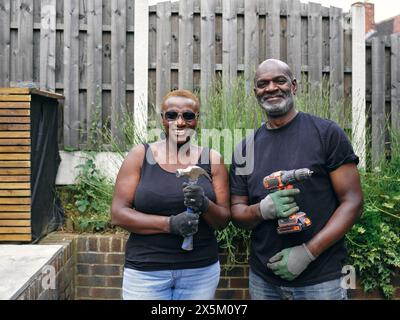 Couple avec des outils de construction sur le patio Banque D'Images