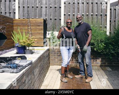 Couple avec des outils de construction sur le patio Banque D'Images