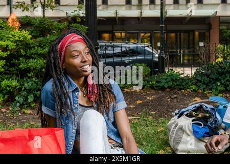 USA, jeune femme avec des dreadlocks assis dans le parc Banque D'Images