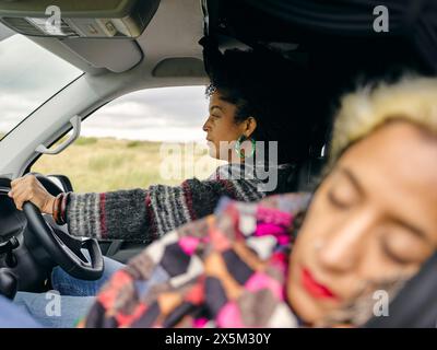Femmes conduisant et dormant en voiture Banque D'Images