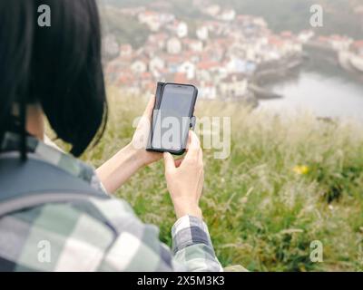 Royaume-Uni, gros plan d'une femme randonneuse regardant la carte sur un téléphone intelligent dans le paysage Banque D'Images